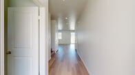 Located in Yucaipa, CA, this two-story home offers four bedrooms, three bathrooms, and a thoughtful layout spread across two floors. The main level features an open-concept kitchen and living area with crisp white shaker cabinetry, stainless steel appliances including a refrigerator, range, and microwave, and a central island — all complemented by recessed lighting and warm light wood flooring that runs throughout the home. Sliding glass doors connect the living area to the outdoors, filling the space with natural light. Upstairs, the four bedrooms are bright and well-sized, with large windows offering views of the surrounding neighborhood. The primary bedroom includes a dedicated closet with built-in shelving. The three bathrooms are finished in a clean, modern style with white vanities featuring brushed nickel hardware, wood-look flooring, and full shower/tub combinations. An attached garage with concrete flooring provides convenient enclosed parking and storage. The exterior features a stucco facade, a wide concrete driveway, and a fully enclosed backyard with vinyl privacy fencing, block walls, and gravel and mulch landscaping — ideal for low-maintenance outdoor living under the Southern California sun.