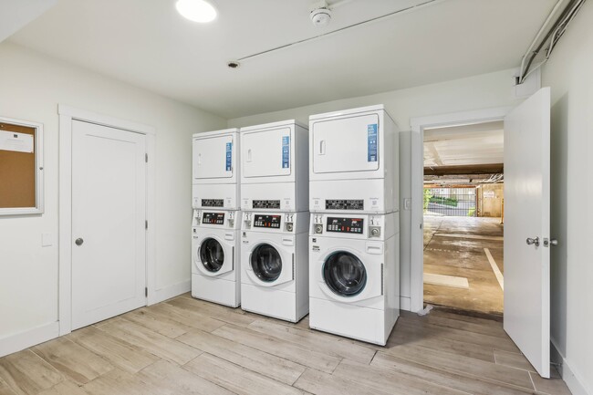 Laundry room with washing machines neatly arranged on a wooden floor - 2369 Le Conte Avenue