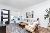 Located at 8306 W State St in Boise, Idaho, this single-floor residence offers a thoughtfully designed layout that balances functionality with contemporary style. The open-concept living and dining area serves as the heart of the home, featuring warm wood flooring, recessed lighting, and a clean, neutral color palette that lends a welcoming ambiance. The living space comfortably accommodates a full seating arrangement and flows naturally into the dining area and kitchen.

The kitchen is well-appointed with light maple upper cabinetry, contrasting dark lower cabinets, quartz countertops, a marble-effect tile backsplash, and a full suite of stainless steel appliances. A generously sized dining table sits adjacent to the kitchen, ideal for everyday meals or entertaining.

Two bedrooms offer natural light through windows fitted with roller shades. The primary bedroom features dual windows, creating a bright and airy retreat. A dedicated den provides a flexible space suitable for a home office or reading room. Both bathrooms include wood-tone vanities, light countertops, wood flooring, and shower areas with curtained enclosures. The overall design is cohesive, modern, and move-in ready.