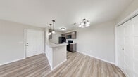 Located at 778 Osage Rd in Willard, Missouri, this single-story, 2-bedroom, 2-bathroom home offers a practical and comfortable layout with clean, modern finishes throughout. The living room serves as a welcoming centerpiece, featuring wood-look luxury vinyl plank flooring, neutral gray walls, a ceiling fan with light fixture, and a glass-panel door alongside windows that invite natural light and outdoor views. The open-concept kitchen and dining area is well-equipped with dark espresso cabinetry, light countertops, black appliances including a refrigerator, range, and dishwasher, and a peninsula with pendant lighting that provides both prep space and a casual dining area. A chandelier overhead adds a touch of elegance to the dining side. Both bedrooms are carpeted for comfort, each featuring ceiling fans, natural light from windows, and closet access — three closets are distributed throughout the home for generous storage. The two bathrooms each include a full tub-shower combination with clean white surrounds and chrome fixtures. Additional spaces include a dedicated laundry room, a utility room, and a hallway connecting the private areas of the home. The overall design is clean, neutral, and move-in ready.