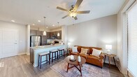 Located at 5220 Center St in Williamsburg, VA, this one-bedroom, one-bathroom residence offers a thoughtfully designed open-concept layout across a single floor. The living area is bright and welcoming, featuring large floor-to-ceiling windows and a glass-panel balcony door that fills the space with natural light and provides outdoor access. A ceiling fan adds comfort to the living room, which flows seamlessly into the kitchen.

The kitchen is well-appointed with rich dark cabinetry, granite countertops, and a full suite of stainless steel appliances including a refrigerator, range, microwave, and dishwasher. A peninsula with bar seating and pendant lighting serves as both a functional workspace and a casual dining area.

The generously sized primary bedroom features plush carpet, a ceiling fan, and a window with outdoor views. It connects directly to the full bathroom, which includes a granite vanity, tub-shower combination, and wood-look flooring. Two closets provide ample storage throughout the unit, and a dedicated laundry area adds everyday convenience.

Wood-look flooring in the main living areas and neutral wall tones throughout create a cohesive, modern aesthetic that makes this Williamsburg residence both functional and inviting.