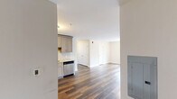 Located at 998 N Washington Ave in Green Brook, NJ, this well-appointed 2-bedroom, 1-bathroom unit offers a thoughtfully designed single-floor layout with modern finishes throughout. Rich, dark hardwood-style flooring runs continuously across the entire space, creating a cohesive and warm aesthetic.

The kitchen is a standout feature, equipped with a full suite of stainless steel appliances including a refrigerator, electric range, over-the-range microwave, and dishwasher. Light gray shaker-style cabinetry pairs elegantly with stone-look granite countertops and a classic white subway tile backsplash. The kitchen flows naturally into the combined living area, making it ideal for everyday living and entertaining.

Both bedrooms are comfortably sized and bathed in natural light from large double-hung windows that frame outdoor views of the surrounding greenery and grounds. Each room includes closet access and wall-mounted HVAC units for year-round comfort. The primary bedroom features a double-door closet for generous storage.

The bathroom is finished with a white vanity, matching granite countertop, a framed mirror, and clean, neutral wall tones. Additional storage is provided by a dedicated closet. The overall palette of soft whites and warm wood tones gives the unit a clean, move-in-ready feel.