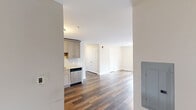 Located at 998 N Washington Ave in Green Brook, NJ, this well-appointed 2-bedroom, 1-bathroom unit offers a thoughtfully designed single-floor layout with modern finishes throughout. Rich, dark hardwood-style flooring runs continuously across the entire space, creating a cohesive and warm aesthetic.

The kitchen is a standout feature, equipped with a full suite of stainless steel appliances including a refrigerator, electric range, over-the-range microwave, and dishwasher. Light gray shaker-style cabinetry pairs elegantly with stone-look granite countertops and a classic white subway tile backsplash. The kitchen flows naturally into the combined living area, making it ideal for everyday living and entertaining.

Both bedrooms are comfortably sized and bathed in natural light from large double-hung windows that frame outdoor views of the surrounding greenery and grounds. Each room includes closet access and wall-mounted HVAC units for year-round comfort. The primary bedroom features a double-door closet for generous storage.

The bathroom is finished with a white vanity, matching granite countertop, a framed mirror, and clean, neutral wall tones. Additional storage is provided by a dedicated closet. The overall palette of soft whites and warm wood tones gives the unit a clean, move-in-ready feel.