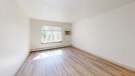 Located at 1240 Oak Terrace Dr in Traverse City, MI, this one-bedroom, one-bathroom unit offers a well-organized, single-floor layout designed for comfortable, efficient living. Light wood-style flooring runs throughout the space, lending a clean and cohesive look to every room.

The combined kitchen and living area serves as the heart of the unit. The galley-style kitchen is outfitted with warm oak cabinetry, light countertops, a double-basin sink, a white electric range, and a full-size refrigerator — providing ample storage and functional workspace. A peninsula counter separates the kitchen from the entry, creating a natural transition into the living area, which receives generous natural light through a large window overlooking a wooded landscape.

The bedroom is a comfortable, private retreat featuring a built-in double closet with bi-fold doors and a window that frames lush, tree-lined views. Baseboard heating runs along the perimeter, ensuring year-round comfort.

The bathroom is thoughtfully equipped with accessibility in mind, including multiple grab bars, a full-sized tub/shower combo, and a wood-toned vanity with a light countertop. Light-toned walls and wood-style flooring maintain a clean, consistent aesthetic throughout.