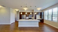 Step into a world of elegance and comfort in this exquisite Cedarburg apartment. The heart of this home is a breathtaking open-concept kitchen and living area, where culinary dreams come to life. Sleek stainless steel appliances, rich dark wood cabinetry, and gleaming quartz countertops create a chef's paradise. The kitchen island, perfect for casual dining or entertaining, seamlessly connects to the living space.

Natural light floods through expansive windows, illuminating the warm wood flooring and creating an inviting atmosphere. The living area, with its generous proportions, offers endless possibilities for relaxation and socializing. Imagine cozy movie nights or hosting sophisticated dinner parties in this versatile space.

The primary bedroom, a spacious 190 sq ft retreat, promises tranquility and comfort. Three additional bedrooms provide ample space for family, guests, or home offices, allowing you to curate your ideal lifestyle. The luxurious bathroom features a double vanity with ample storage, creating a spa-like experience in your own home.

Modern conveniences abound, including an in-unit laundry room for ultimate convenience. The apartment's thoughtful design extends to a built-in desk area, perfect for remote work or study. Floor-to-ceiling windows in the living area frame picturesque views and lead to a private outdoor space, seamlessly blending indoor and outdoor living.

Located in the desirable Arabelle Apartments, this home offers not just a living space, but a lifestyle. Embrace the perfect balance of comfort, style, and functionality in this must-see property. Your aspirational home awaits – schedule a viewing today and step into the life you've always dreamed of.
