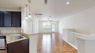Located at 5303 S Mason Rd in Katy, TX, this two-story home offers a practical and well-appointed layout across two levels. The ground floor houses an attached garage with an automatic opener, providing secure vehicle storage and additional utility space. The main living level features an open-concept kitchen and living room, where warm hardwood-style flooring, crown molding, and a ceiling fan create a bright and welcoming atmosphere. Natural light flows in through large windows and a front entry door with transom window. The kitchen is outfitted with dark espresso cabinetry, granite countertops, a tile backsplash, and a full suite of stainless steel appliances including a range, microwave, and dishwasher. The spacious bedroom is carpeted for comfort, features a ceiling fan, a large window with neighborhood views, and connects conveniently to a closet. The full bathroom includes a tiled soaking tub and shower combination with chrome fixtures and hardwood-style flooring. A dedicated laundry room accommodates a full-size washer and dryer with built-in shelving above. A staircase and hallway connect the levels efficiently, completing this functional and comfortable home.