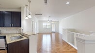 Located at 5303 S Mason Rd in Katy, TX, this two-story home offers a practical and well-appointed layout across two levels. The ground floor houses an attached garage with an automatic opener, providing secure vehicle storage and additional utility space. The main living level features an open-concept kitchen and living room, where warm hardwood-style flooring, crown molding, and a ceiling fan create a bright and welcoming atmosphere. Natural light flows in through large windows and a front entry door with transom window. The kitchen is outfitted with dark espresso cabinetry, granite countertops, a tile backsplash, and a full suite of stainless steel appliances including a range, microwave, and dishwasher. The spacious bedroom is carpeted for comfort, features a ceiling fan, a large window with neighborhood views, and connects conveniently to a closet. The full bathroom includes a tiled soaking tub and shower combination with chrome fixtures and hardwood-style flooring. A dedicated laundry room accommodates a full-size washer and dryer with built-in shelving above. A staircase and hallway connect the levels efficiently, completing this functional and comfortable home.