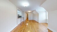 Located at 255 Ellsworth Ave in New Haven, CT, this 2-bedroom, 1-bathroom residence offers a thoughtfully laid-out single-floor plan with distinctive architectural character. The space is defined by beautiful hardwood floors that run throughout the main living areas and bedrooms, complemented by sloped ceilings that add a cozy, attic-inspired charm to the home.

The combined dining and living area is open and welcoming, with a breakfast bar connecting it to the kitchen — ideal for both casual dining and entertaining. The kitchen is well-equipped, featuring a stainless steel electric range, built-in open shelving for pantry storage, warm wood cabinetry, a mosaic tile backsplash, a dark countertop, and tile flooring. Natural light flows in through windows with blinds, offering neighborhood views.

The primary bedroom is generously sized, with sloped ceilings and hardwood floors, while the second bedroom is compact yet functional with its own angled ceiling detail and window. Both rooms benefit from four closets distributed throughout the unit. A hallway connects the rooms efficiently.

The bathroom features a full tub-shower combo, built-in corner shelving tucked under the sloped roofline, a medicine cabinet, and tile flooring. The neutral, white-toned palette throughout the home creates a clean and bright atmosphere.