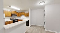 Located in Marietta, GA, this single-floor, one-bedroom, one-bathroom unit offers a well-organized and efficient layout. The living room is generously sized, featuring neutral-toned carpet, a textured ceiling, and a sliding glass door that opens to a private patio with pleasant outdoor views, filling the space with natural light. Adjacent to the living area, the kitchen is equipped with warm honey-toned wood cabinetry, stainless steel appliances including a gas range, microwave, and refrigerator, complemented by white countertops and light wood-style flooring. A breakfast bar provides additional counter space and casual dining convenience. A dedicated laundry area with a stacked washer and dryer unit is seamlessly integrated near the kitchen. The bedroom offers a comfortable footprint with carpeted flooring, a window for natural light, and direct access to a walk-in closet outfitted with dual shelving systems on both sides for ample storage. The bathroom features a full tub-shower combination with white tile surround, chrome fixtures, and wood-style flooring. A hallway connects the rooms cohesively, completing this practical and well-appointed single-level home.