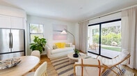Located in Bonita Springs, FL, this two-story home offers a thoughtfully designed layout spread across two floors. Warm hardwood flooring flows throughout, complementing crisp white walls and an abundance of natural light. The main level features an open-concept living, dining, and kitchen area, where large sliding glass doors lead to a private patio framed by lush tropical greenery — ideal for outdoor relaxation. The kitchen is outfitted with white shaker cabinetry, open shelving, white tile backsplash, and stainless steel appliances. A hallway with a guest bath connects the main living spaces. Upstairs, the spacious primary bedroom offers generous closet space and treetop views through bright windows. The second bedroom is equally inviting, with natural light and cozy finishes. Three full bathrooms serve the home, including one with vaulted ceilings. Additional features include a dedicated laundry area, multiple closets, and a second patio for added outdoor living. The home's coastal-inspired aesthetic, efficient floor plan, and verdant surroundings make it a comfortable retreat in the heart of Southwest Florida.
