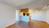 Located at 4350 Galbraith Dr in Sacramento, CA, this single-floor, 2-bedroom, 2-bathroom unit offers a practical and well-organized layout. The open living area is finished with warm wood-look laminate flooring and features a large window with vertical blinds that allows natural light to fill the space. A textured ceiling runs throughout the unit, adding a classic residential character.

The kitchen is efficiently designed with light oak cabinetry providing ample storage, white laminate countertops, a double sink, and a full suite of black appliances including a refrigerator, electric range, microwave, and dishwasher. A peninsula counter connects the kitchen to the living area, enhancing the open flow between spaces.

Both bedrooms are carpeted and bathed in natural light through windows fitted with vertical blinds. The spacious primary bedroom includes access to a closet with built-in shelving and cabinetry. The second bedroom is cozy and well-proportioned with clean white walls.

The two bathrooms are identically appointed, each featuring wood-look flooring, a tub-shower combo with a curved curtain rod, a vanity with a light countertop, and a mirror. A hallway connects the bedrooms and bathrooms, keeping the layout cohesive and functional.