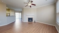 Located at 508 Pride Avenue in Herndon, Virginia, this three-story townhouse offers a well-organized layout across its floors, with a garage on the ground level, main living spaces on the middle floor, and bedrooms on the upper floor. The classic brick exterior with manicured landscaping creates an inviting first impression. The main living level features a spacious living room with warm hardwood-style flooring, crown molding, a ceiling fan, and a tile-surround fireplace that serves as a focal point. Sliding glass doors lead to an outdoor space, filling the room with natural light. The combined dining room and kitchen is well-appointed with white cabinetry, stainless steel appliances including a gas range, microwave, and refrigerator, complemented by light wood-style flooring. Upstairs, the carpeted bedrooms offer comfortable retreats, with the primary bedroom providing a generous footprint. The stairways are carpeted and naturally lit through well-placed windows. Both bathrooms feature clean white vanities with updated fixtures and framed mirrors. Additional highlights include a laundry area, a bonus room, and an impressive six closets distributed throughout the home, providing ample storage.