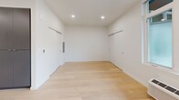 Located at 3956 N Vancouver Ave in Portland's vibrant North Williams corridor, this thoughtfully designed studio unit offers a clean, contemporary living experience across a single level. The open-concept kitchen and living area serves as the heart of the space, featuring light hardwood flooring, recessed lighting, and large windows that invite abundant natural light. A glass door opens directly to a private balcony, extending the living area outdoors with neighborhood views.

The kitchen is outfitted with flat-front, dark taupe cabinetry, bright white quartz countertops, and a full suite of stainless steel appliances including a gas range, microwave, dishwasher, and refrigerator. A peninsula with an undermount sink provides additional prep space and a natural divider within the open layout.

The bathroom is finished in a minimalist style with large-format light tile flooring, a sleek floating vanity with white countertop, an illuminated mirror, and clean white walls. A dedicated closet and in-unit laundry area add practical convenience. Throughout the unit, the crisp white walls and consistent light wood flooring create a bright, cohesive aesthetic suited to modern urban living.