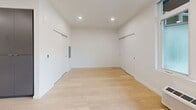 Located at 3956 N Vancouver Ave in Portland's vibrant North Williams corridor, this thoughtfully designed studio unit offers a clean, contemporary living experience across a single level. The open-concept kitchen and living area serves as the heart of the space, featuring light hardwood flooring, recessed lighting, and large windows that invite abundant natural light. A glass door opens directly to a private balcony, extending the living area outdoors with neighborhood views.

The kitchen is outfitted with flat-front, dark taupe cabinetry, bright white quartz countertops, and a full suite of stainless steel appliances including a gas range, microwave, dishwasher, and refrigerator. A peninsula with an undermount sink provides additional prep space and a natural divider within the open layout.

The bathroom is finished in a minimalist style with large-format light tile flooring, a sleek floating vanity with white countertop, an illuminated mirror, and clean white walls. A dedicated closet and in-unit laundry area add practical convenience. Throughout the unit, the crisp white walls and consistent light wood flooring create a bright, cohesive aesthetic suited to modern urban living.