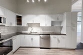 Located at 24 Mt Vernon St in Lynn, MA, this well-appointed one-bedroom, one-bathroom unit offers a thoughtfully designed layout across a single floor. Light-toned luxury vinyl plank flooring flows throughout the living areas and bedroom, providing a clean, cohesive aesthetic.

The kitchen is a standout feature, showcasing a full suite of stainless steel appliances including a refrigerator, range, microwave, and dishwasher. Crisp white flat-panel cabinetry extends to the ceiling, offering generous storage, while dark countertops provide a striking contrast. A classic subway tile backsplash adds texture, and track lighting illuminates the space efficiently.

The bedroom is comfortably sized and benefits from dual windows that invite natural light and street views. High ceilings enhance the sense of space, and a built-in closet provides practical storage. Light-toned vinyl plank flooring continues here, maintaining the unit's consistent, modern feel.

The bathroom features dark slate-style tile flooring, a white vanity with classic hardware, and tall storage closets, combining function with clean design.

A welcoming entry hallway connects all rooms and provides convenient access to the stainless steel refrigerator just off the front door. The overall ambiance is modern, clean, and move-in ready.
