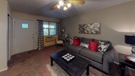 Located at 2196 Rockdell Dr. in Fairborn, Ohio, this single-floor residence offers a well-organized and comfortable layout designed for everyday living. The living room serves as the heart of the home, featuring warm carpeted flooring, a ceiling fan with light fixture, and a window dressed with patterned curtains that allow natural light to filter in. The space comfortably accommodates a full seating arrangement alongside a dedicated workspace area near the window, creating a versatile and functional room.

The bedroom is generously proportioned, with soft carpeted floors and windows adorned with sheer, light-diffusing curtains. The room provides ample space for a full-sized bed and additional furniture, offering a calm and restful atmosphere.

The bathroom features warm wood-look flooring, a white vanity with under-sink cabinetry, and a full tub and shower combination with a chevron-patterned curtain, lending a clean and coordinated aesthetic throughout.

The kitchen is equipped with white cabinetry above and below the countertop, a stainless steel sink, light-toned countertops, and includes a dishwasher — providing practical storage and workspace for meal preparation. Overall, the unit presents a clean, cohesive design with neutral tones throughout.