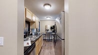 Located at 1025 Second St NE in Hopkins, MN, this one-bedroom, one-bathroom unit delivers a well-organized, single-floor layout designed to maximize every square foot. The galley-style kitchen features light maple cabinetry, dark granite countertops, a double stainless steel sink, and stainless steel appliances including a range, microwave, and dishwasher, all set above durable wood-look flooring. Adjacent to the kitchen is a dining nook with space for a bistro-style table, ideal for casual meals. The living room offers a bright, open feel with large windows dressed in vertical blinds that allow ample natural light, complemented by warm neutral walls, wood-look flooring, and a textured ceiling. The bedroom features plush carpeting, a generous sliding-door closet, a wall-mounted A/C unit, and a window with outdoor views, creating a comfortable and private retreat. The full bathroom includes a tub/shower combination, a white vanity with storage, and tile flooring. Throughout the unit, a cohesive neutral palette and consistent finishes create a calm, functional living environment suited for everyday comfort.