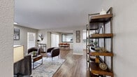 This single-story, 2-bedroom, 3-bathroom residence offers a thoughtfully designed open-concept layout with hardwood-style flooring throughout. The spacious living room serves as the heart of the home, anchored by a classic fireplace framed by two large windows that invite natural light. The open flow connects seamlessly to the dining area and kitchen, which features white cabinetry with matte black hardware, a herringbone tile backsplash, white quartz countertops, and stainless steel appliances. A walk-in pantry or laundry closet adds practical storage. The dining area provides access to a private balcony through a sliding glass door dressed with vertical blinds. The generously sized primary bedroom includes a floor-to-ceiling mirrored sliding closet and warm neutral tones. The second bedroom is equally well-proportioned with ample closet space. All three bathrooms are finished with white cabinetry, quartz countertops, and bold black-framed mirrors and hardware accents, with tub-shower combinations in a clean, bright aesthetic. Warm neutral paint tones, modern light fixtures, and consistent wood-look flooring create a cohesive and welcoming ambiance throughout the entire residence.