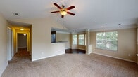 Located at 4510 Glen Forest Dr in Greenville, SC, this single-story home offers a thoughtfully designed open-concept layout with a warm, neutral palette throughout. The expansive living area is anchored by a vaulted ceiling and a ceiling fan, while plush wall-to-wall carpeting adds comfort underfoot. A dedicated dining nook with a distinctive bay window configuration, decorative columns, and dark hardwood flooring creates an elegant transition from the main living space, bathing the area in natural light from multiple windows overlooking greenery outside.

The kitchen features white cabinetry, dark granite-style countertops, a double-basin stainless steel sink, and a pass-through opening that connects seamlessly to the living area, maintaining an open and airy feel. A dishwasher is also included.

The bedrooms are generously sized, each equipped with ceiling fans and windows that invite natural light. Walk-in closets with wire shelving systems provide ample, well-organized storage space.

The bathroom includes a dual-sink vanity with dark countertops, a soaking tub with tiled surround featuring a neutral accent border, and access to a walk-in closet. The overall ambiance of this home is bright, clean, and functional.