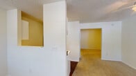 Located at 3810 Portofino Ct in Wilmington, NC, this single-floor residence offers a straightforward and functional layout designed for comfortable everyday living. The living area greets visitors at the front entry, featuring plush carpeted flooring, textured ceilings, and multiple windows dressed with blinds that allow generous natural light to fill the space. A ceiling fan provides added comfort, and a wall-mounted air conditioning unit ensures year-round climate control.

The kitchen is efficiently arranged with white cabinetry, an electric range, a sink, and a refrigerator, all set atop rich, dark hardwood-style flooring that extends into the adjacent hallway. An electrical panel is conveniently accessible nearby.

The bedroom areas are carpeted and neutral in tone, offering clean, move-in-ready spaces. One room features a ceiling fan with light fixture, while additional rooms provide quiet, versatile spaces suitable for sleeping or home office use. A dedicated closet offers practical storage.

The full bathroom is finished with dark hardwood-style flooring, a tub-shower combination, a vanity with sink, a towel bar, and a baseboard heater, maintaining a clean, white aesthetic throughout. Overall, the residence presents a practical and well-organized living environment in a convenient Wilmington location.