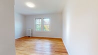Located at 39 Charter Oak Pl in Hartford, Connecticut, this single-floor unit offers a clean, functional layout with a consistent design aesthetic throughout. Warm-toned hardwood flooring runs continuously across the living spaces and bedrooms, lending the home a cohesive and inviting feel.

The living area is bright and open, benefiting from generous natural light that streams through multiple double-hung windows. Classic cast-iron radiators are present in the main rooms, providing efficient radiant heating and a nod to the building's traditional character. Neutral light-gray walls create a versatile backdrop throughout the space.

The kitchen is equipped with white cabinetry, dark countertops, a gas range, a refrigerator, and a single-basin sink with a pull-down faucet. A window above the counter allows natural light into the workspace. Wood-look flooring completes the kitchen's clean, practical design.

The bathroom features a full tub-shower combination, a white vanity with under-cabinet storage, a wall-mounted mirror, and wood-look tile flooring. The fixtures are finished in brushed nickel, maintaining a modern and cohesive look.

The bedrooms are well-proportioned, each featuring hardwood floors, bright windows with views of surrounding greenery and neighboring brick buildings, and radiator heating. The overall ambiance of the unit is bright, tidy, and move-in ready, offering comfortable city living in Hartford's Charter Oak neighborhood.