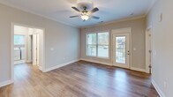 Located in Knoxville, TN, this well-appointed single-story home offers three bedrooms, two bathrooms, and a thoughtfully designed layout that maximizes comfort and functionality. The heart of the home is an open-concept living, dining, and kitchen area bathed in natural light. The kitchen stands out with crisp white shaker cabinets, granite countertops, a shiplap-accented island with a built-in sink, pendant lighting, stainless steel appliances, and a tile backsplash — all complemented by warm wood-look flooring that flows throughout the home. Crown molding and recessed lighting add a refined touch to the communal spaces. The living area features a ceiling fan and direct access to an outdoor balcony, offering pleasant neighborhood views. Each bedroom is generously sized with large windows that bring in ample natural light. The primary bedroom includes its own closet, and the home is equipped with five closets total, providing exceptional storage. Both bathrooms feature tub-shower combinations with chrome fixtures and marble-look tile flooring. A dedicated laundry room with full-size washer and dryer hookups adds everyday convenience, along with a pantry and utility room rounding out this functional and attractive home.