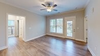 Located in Knoxville, TN, this well-appointed single-story home offers three bedrooms, two bathrooms, and a thoughtfully designed layout that maximizes comfort and functionality. The heart of the home is an open-concept living, dining, and kitchen area bathed in natural light. The kitchen stands out with crisp white shaker cabinets, granite countertops, a shiplap-accented island with a built-in sink, pendant lighting, stainless steel appliances, and a tile backsplash — all complemented by warm wood-look flooring that flows throughout the home. Crown molding and recessed lighting add a refined touch to the communal spaces. The living area features a ceiling fan and direct access to an outdoor balcony, offering pleasant neighborhood views. Each bedroom is generously sized with large windows that bring in ample natural light. The primary bedroom includes its own closet, and the home is equipped with five closets total, providing exceptional storage. Both bathrooms feature tub-shower combinations with chrome fixtures and marble-look tile flooring. A dedicated laundry room with full-size washer and dryer hookups adds everyday convenience, along with a pantry and utility room rounding out this functional and attractive home.