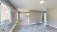 Located at 227 Washington Ave in Blackwood, NJ, this 2-bedroom, 1-bathroom unit offers a clean, modern aesthetic across its single-floor layout. The combined living room and kitchen area forms the heart of the home, featuring light-toned luxury vinyl plank flooring that flows consistently throughout the entire space. The living area is bathed in natural light from large windows and is equipped with a wall-mounted HVAC unit for year-round comfort. The kitchen is appointed with white cabinetry lining both walls, granite-style countertops, a stainless steel sink, and a skylight-style ceiling fixture that brightens the galley-style workspace. Both bedrooms are generously proportioned, each featuring sliding double-door closets, neutral gray walls, and large windows that invite ample natural light. Baseboard heating runs along the perimeter of each room, ensuring consistent warmth. The bathroom features wood-look tile flooring, a white vanity with mirror, and a full bathtub, maintaining the clean and cohesive design language found throughout the unit. Crisp white trim and soft gray walls create a neutral, move-in-ready palette that complements a variety of interior styles.