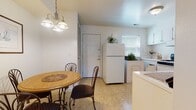 This two-floor home offers a well-organized layout designed for comfortable everyday living. The kitchen is bright and efficiently arranged, featuring white cabinetry, white appliances including a gas range, dishwasher, and refrigerator, complemented by light-toned countertops and tile flooring. An in-unit washer and dryer add everyday convenience. Adjacent to the kitchen, a cozy dining nook accommodates a round table with seating for four, lit by a classic chandelier overhead — ideal for casual meals.

The living room provides a warm and inviting gathering space, with carpet flooring, decorative wall sconces, and an open feel enhanced by soft ambient lighting. The bedrooms are carpeted and generously sized, each offering louvered bi-fold closets with built-in shelving for ample storage. The primary bedroom features a window with views of surrounding greenery, filling the room with natural light. Additional bedrooms are equally well-appointed with closet space.

The bathroom is clean and functional, featuring a light blue tub-shower unit with a curtained enclosure and classic tile flooring in a diamond pattern. Throughout the home, a neutral white and beige palette creates a calm, cohesive atmosphere across both floors.