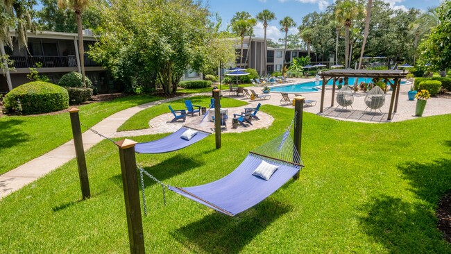 Deléitese con las elegantes amenidades al aire libre, como el maravilloso jardín de hamacas, la animada hoguera y la vibrante piscina estilo centro vacacional. - Lakewood Village