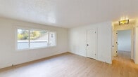 This 680 square foot apartment in Tigard, Oregon offers a thoughtfully designed living space with modern amenities. The single-story layout comprises two bedrooms, one bathroom, a kitchen, and a living room. The primary bedroom, measuring 140 square feet, provides a comfortable retreat.

Throughout the apartment, light-toned wood flooring creates a warm and inviting atmosphere. Large windows in each room allow natural light to flood the space, enhancing the sense of openness. The living area features an archway leading to an adjacent room, promoting an open-concept feel.

The kitchen boasts a contemporary design with white cabinetry, stainless steel appliances, and contrasting dark tile flooring. It includes a full-size refrigerator, oven, and ample counter space for meal preparation.

The bathroom is efficiently designed with a white vanity, toilet, and a bathtub-shower combination. Safety features such as grab bars are installed for added convenience.

Each bedroom offers closet space with sliding doors, providing essential storage solutions. The property's location at 11380 SW Greenburg Rd ensures easy access to local amenities while maintaining a residential feel.