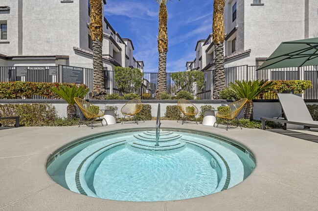 The Michael B's luxury apartment complex boasts a tranquil jacuzzi retreat, surrounded by lush palm trees and sleek architectural marvels. Dive into serenity amidst the cityscape. - The Michael B Townhomes and Flats