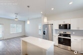 Located at 9000 Little Palm Way in Venice, FL, this single-story, one-bedroom, one-bathroom home offers a clean, modern design with an efficient and well-organized layout. Light-toned luxury vinyl plank flooring runs throughout, complementing the neutral wall palette and creating a bright, cohesive aesthetic.

The open-concept living and dining area is filled with natural light from multiple windows dressed with white blinds, and a ceiling fan adds comfort to the airy space. The kitchen is a standout feature, outfitted with crisp white shaker cabinetry, white quartz countertops, a subway tile backsplash in soft gray, and a full suite of stainless steel appliances including a French door refrigerator, electric range, microwave, and dishwasher. A central island provides additional prep and dining space, while pendant lighting adds a polished touch.

The spacious bedroom includes ample natural light, a ceiling fan, and access to two closets. The bathroom features a white vanity with brushed nickel hardware and a glass-enclosed walk-in shower. A dedicated laundry room with a full-size washer and dryer adds everyday convenience. The private patio with a grassy area rounds out this well-appointed home.