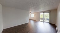 Located at 1868 Sunset Ave in Cincinnati, Ohio, this single-floor, two-bedroom, one-bathroom residence offers a practical and well-appointed layout. Rich, dark hardwood-style flooring flows throughout the living areas and bedrooms, providing a warm and cohesive aesthetic. The open living room is generously sized, featuring a textured ceiling, a ceiling fan with light fixture, baseboard heating, and a sliding glass door that leads to an outdoor balcony, filling the space with natural light and views of surrounding greenery. The kitchen is thoughtfully designed with crisp white shaker-style cabinetry, light stone-look countertops, and black appliances including a refrigerator, electric range with overhead exhaust, and dishwasher, all set atop durable wood-look flooring. The two bedrooms are comfortable and bright, each with hardwood-style floors, baseboard heating, and ample natural light from windows. The primary bedroom includes a built-in closet with bifold doors. The bathroom features a full tub-shower combo finished with clean white subway tile surround and chrome fixtures. A hallway and dedicated closet complete the functional floor plan, making this a well-rounded and move-in-ready residence.