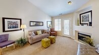 Located in Layton, Utah, this 2-bedroom, 1-bathroom single-floor residence offers a thoughtfully organized layout that maximizes comfort and functionality. The living room is a welcoming focal point, featuring vaulted ceilings that enhance the sense of openness, plush carpet flooring, a tiled fireplace with a built-in display niche above, and a glass door that invites natural light and provides outdoor access. Adjacent to the living area, the galley-style kitchen is outfitted with white cabinetry trimmed in wood, ample counter space, and a full suite of appliances including an electric range and refrigerator, all set on light tile flooring. The primary bedroom is generously sized with an arched window that brings in soft natural light, while the second bedroom also features a window and comfortable carpet flooring. Both rooms offer closet storage, including a set of double sliding-door closets. The shared bathroom includes a wide vanity with wood-accented cabinetry, a large mirror with overhead lighting, and a shower-tub combination. A dedicated in-unit laundry room with wire shelving adds everyday convenience. The hallway connects all areas cleanly, completing this efficient and comfortable single-level home.