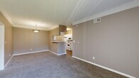 Located at 5525 Elkhorn Dr in Indianapolis, Indiana, this single-floor, three-bedroom, two-bathroom home offers a practical and well-organized layout. The open-concept living and dining area flows directly into the kitchen, which features white cabinetry, white appliances including a range, microwave, refrigerator, and dishwasher, alongside wood-look flooring and ample counter space. A breakfast bar separates the kitchen from the living and dining area, which is finished with neutral carpet and crown molding.

The primary bedroom is generously sized and includes a walk-in closet outfitted with wire shelving and hanging rods for abundant storage. The two additional bedrooms are carpeted and feature neutral wall tones, with one offering its own closet access. Both bathrooms are finished with wood-look flooring, white vanities, and tub-shower combinations with tiled surrounds.

A dedicated laundry room includes wire shelving overhead and accommodates a full-size washer and dryer. Throughout the home, neutral taupe and gray tones create a cohesive and understated aesthetic. Textured ceilings, consistent trim work, and natural light from windows in multiple rooms round out this functional and well-maintained residence.