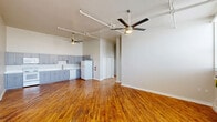 Located at 417 N 15th St in Allentown, PA, this three-bedroom, one-bathroom residence offers a well-designed single-floor layout with a bright, open feel throughout. Rich hardwood flooring flows seamlessly across the entire space, complementing the neutral gray-toned walls and crisp white trim.

The open-concept living and kitchen area is the centerpiece of the home, featuring soaring ceilings with exposed ceiling fans and track lighting that give the space an airy, loft-inspired character. The kitchen is equipped with gray shaker-style cabinetry, white countertops, a full suite of white appliances including a range, microwave, dishwasher, and refrigerator, and a single-basin sink — all arranged along a generous wall-length run of cabinetry.

Each of the three bedrooms features gleaming hardwood floors, wall-unit climate control, and large windows that invite abundant natural light and offer views of the surrounding Allentown neighborhood. One bedroom includes a closet, while others provide open, flexible layouts.

The bathroom is clean and functional, appointed with a white vanity, white countertop, a lighted mirror, and wood-look tile flooring. A hallway connects the bedrooms and bathroom, creating a logical and efficient flow throughout the home. A staircase is also present within the unit.