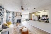 Located at 10 Rimington Lane in Decatur, Georgia, this single-story 2-bedroom, 2-bathroom residence offers a well-designed open floor plan filled with natural light. The combined living and dining area serves as the heart of the home, featuring light wood-style flooring, a ceiling fan, a classic fireplace, and large windows dressed with decorative blue-and-white patterned curtains. The dining area accommodates a full-size table and benefits from an expansive set of windows that flood the space with daylight. The galley-style kitchen is equipped with stainless steel appliances — including a refrigerator, electric range, and microwave — complemented by white cabinetry, dark countertops, and a convenient pass-through view into the dining area. The primary bedroom offers a ceiling fan, a window with natural light, and ample closet space, while the second bedroom is comparably sized and similarly appointed. Both bathrooms feature tub/shower combinations with white tile surrounds. Additional spaces include a laundry area, pantry, utility room, and three closets for generous storage. The layout flows efficiently through a central hallway, creating a cohesive and functional living environment throughout.