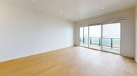 Located on Coastline Drive in Malibu, CA, this 2-bedroom, 3-bathroom residence offers a clean, contemporary design throughout its well-appointed single-floor layout. Light hardwood flooring runs continuously through the living areas and bedrooms, complementing the bright, white interior palette and recessed lighting overhead.

The kitchen is thoughtfully designed with crisp white shaker cabinetry, stainless steel appliances including a gas range, microwave, dishwasher, and refrigerator, along with light countertops and a undermount sink — all topped by a tray ceiling with recessed lighting.

The living area is a standout, featuring expansive floor-to-ceiling sliding glass doors that open to a private balcony with glass railings, offering sweeping views of the Pacific Ocean and the Malibu coastline. The primary bedroom is generously sized and benefits from the same stunning ocean-facing outlook through large sliding doors. The second bedroom includes mirrored sliding closet doors and multiple windows that bring in natural light.

The bathrooms are finished in clean whites with tile flooring and modern fixtures, including a spacious bathroom with an extended double vanity and wood-framed mirror cabinets. A dedicated laundry room houses a full-size side-by-side washer and dryer with overhead cabinetry for additional storage.