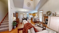 Located in the Deer Valley neighborhood of Ellington, Connecticut, this two-story home offers a well-designed layout that balances open communal spaces with comfortable private quarters. The main floor is anchored by a dramatic great room with soaring vaulted ceilings, highlighted by a decorative ceiling medallion and a skylight that draws in natural light. A fireplace with a classic wood mantel serves as a focal point, while hardwood flooring flows seamlessly through the living, dining, and kitchen areas.

The kitchen features warm honey-toned wood cabinetry, white countertops, a double sink beneath a window, and ample storage. Adjacent to the kitchen, the dining area accommodates a full dining set beneath a traditional chandelier, with convenient access to additional storage. A cozy sitting area with large windows and hardwood floors provides a quiet retreat off the main living space.

Upstairs, the bedrooms are carpeted and feature vaulted ceilings, ceiling fans, and natural light from well-placed windows. The primary bedroom is generously proportioned, while additional rooms offer flexible use as bedrooms or offices. Bathrooms include tile flooring, white cabinetry, large mirrors, and a soaking tub in the main bath, contributing to the home's functional and inviting character throughout.