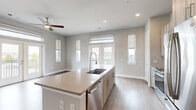 Located in Houston's 77008 zip code, this 2-bedroom, 2-bathroom home offers a well-designed single-floor layout with thoughtful finishes throughout. The open-concept kitchen and living area is a standout, featuring a large center island with a quartz countertop and integrated sink, light wood cabinetry, a white tile backsplash, and stainless steel appliances. Recessed lighting and a ceiling fan complement the space, while multiple windows and French doors flood the area with natural light. The French doors open onto a private balcony with outdoor views. The living area is finished with durable wood-look flooring that flows seamlessly through the main spaces. Both bedrooms are carpeted and include ceiling fans and dedicated closets. The primary bedroom features a spacious walk-in closet with built-in shelving and dual hanging rods for ample storage. The secondary bedroom offers two windows with neighborhood views. The bathrooms are finished with large-format tile surrounds, a tub/shower combo, and wood-toned cabinetry. A dedicated in-unit laundry area accommodates a full-size washer and dryer. Neutral tones and clean finishes give the home a modern, move-in-ready feel.