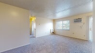 This single-floor unit at 4314 Rocky River Dr in Cleveland, Ohio, offers a functional and straightforward layout spread across several interconnected rooms. The living area is generously proportioned, featuring neutral-toned carpet, textured ceilings, and a wall-mounted heating unit. A window allows natural light to filter in, while a sliding glass door fitted with vertical blinds provides outdoor access. A wall-mounted air conditioning unit ensures year-round comfort.

The bedrooms are carpeted and well-lit, each equipped with ceiling fans and baseboard heating units. Windows in each room frame views of the surrounding neighborhood, and the rooms offer ample wall space for furnishings.

The galley-style kitchen features warm-toned wooden cabinetry, laminate countertops, a stainless steel sink, and wood-look vinyl flooring. White appliances, including a refrigerator and dishwasher, are included. A closet door at the end of the kitchen adds convenient storage.

The bathroom is finished with wood-look vinyl flooring, a white vanity with cabinet storage, a mirrored medicine cabinet, and a tiled shower-tub combination. The overall aesthetic throughout the unit is clean and neutral, providing a versatile canvas for personalization.
