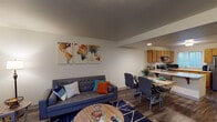 Located at 19700 14 Mile Rd in Big Rapids, Michigan, this multi-floor residential unit spans three levels and offers a thoughtfully designed layout suited for comfortable everyday living. The open-concept main living area seamlessly connects the living room, dining space, and kitchen, creating a cohesive and functional common area. The living room features wood-look plank flooring, recessed lighting, and ample space for relaxed seating arrangements. Adjacent to it, the dining area accommodates a full-sized table, making it ideal for shared meals.

The kitchen is well-equipped with warm oak cabinetry, light countertops, a double-basin sink, a dishwasher, and a black electric range, providing generous storage and prep space. A peninsula counter further extends the workspace and opens toward the dining area.

The bedrooms are comfortably sized, each featuring wood-look flooring, neutral walls, and windows that allow natural light to filter in with views of the surrounding grounds. The bathrooms are clean and functional, with one featuring a full tub-shower combination and warm wood-toned vanity cabinetry. Additional rooms offer flexible space that can be used for a variety of purposes. Throughout, the unit maintains a clean, neutral aesthetic that provides a practical and livable environment.
