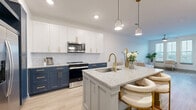 Located at 2370 Sever Rd in Lawrenceville, GA, this well-appointed one-bedroom, one-bathroom residence offers a thoughtfully designed single-floor layout that maximizes every square foot. The open-concept living, dining, and kitchen area serves as the heart of the home, highlighted by a stunning designer kitchen. Two-tone cabinetry — crisp white upper cabinets paired with deep navy lowers — is accented with brushed gold hardware, while a subway tile backsplash and granite-topped island with built-in sink and bar seating add both style and function. Stainless steel appliances, including a French door refrigerator and over-the-range microwave, complete the kitchen. Light wood-look flooring flows throughout the main living areas, complementing the bright, neutral palette. The living room features a ceiling fan and generous windows that invite ample natural light. The carpeted bedroom offers multiple windows, a ceiling fan, and a dedicated closet. The full bathroom is finished with navy cabinetry, gold hardware, granite countertops, and a glass-enclosed shower. Additional conveniences include an in-unit laundry room, a utility room, and a private balcony for outdoor enjoyment.