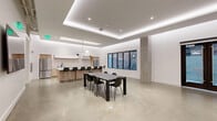 Located at 145 Leavenworth Street in San Francisco, this single-floor space offers a generously sized, open-plan layout designed with a clean, contemporary aesthetic. Polished concrete floors extend throughout, complementing the crisp white walls and lending an industrial-modern character to the interior.

The ceiling architecture is a defining feature, incorporating a recessed tray design with integrated LED cove lighting that casts a soft, ambient glow across the space. Recessed downlights provide additional illumination, ensuring the interior is well-lit throughout.

The kitchen is a central highlight, outfitted with light wood cabinetry, a marble-style backsplash, and sleek white upper cabinets. Stainless steel appliances, including two full-size refrigerators, a cooktop, and a sink with a matte black faucet, provide full functionality. A large island with a white countertop and black bar stools accommodates multiple guests, while a sculptural pendant light fixture adds an artistic touch overhead.

The open main area features a dining table with seating, a skylight for natural light, and dark-framed windows and French doors that face outward. A secondary zone includes a mounted display screen, seating, and interior access doors, making the space adaptable for various uses.