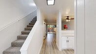 This contemporary townhome in Castro Valley offers 920 square feet of thoughtfully designed living space across two floors. The property boasts two bedrooms, including a spacious 170 square foot primary bedroom, and two updated bathrooms. The interior is characterized by a clean, modern aesthetic with crisp white walls, crown molding, and a mix of plush carpeting and sleek wood-look flooring.

The living area is bright and airy, featuring a sliding glass door that leads to an outdoor space, seamlessly blending indoor and outdoor living. The kitchen showcases a fresh, all-white design with shaker-style cabinets, quartz countertops, and stainless steel appliances, creating a stylish and functional cooking environment.

Both bathrooms have been tastefully updated, featuring modern fixtures, round mirrors, and a combination of tile and wood-look flooring. The home's bedrooms are generously sized, with the primary bedroom offering ample space for relaxation.

Throughout the property, attention to detail is evident in the carefully chosen light fixtures, including a decorative ceiling fan, and thoughtful touches like built-in shelving. The townhome's two-story layout, visible in the 3D model, provides a sense of spaciousness and separation between living and sleeping areas.