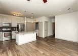 Located at 675 Lafayette Ave in Fayetteville, Georgia, this single-floor residence offers a thoughtfully designed layout with a clean, modern aesthetic throughout. The kitchen serves as a central highlight, showcasing white cabinetry with arched-panel detailing, a mosaic tile backsplash, and a full suite of stainless steel appliances including a refrigerator, range, and microwave. A central island topped with granite countertops provides ample workspace and includes an integrated sink, dishwasher, and pendant lighting overhead, making it both functional and visually appealing.

The living area is finished with warm hardwood-style flooring and features multiple windows dressed with horizontal blinds, allowing generous natural light to fill the space. A ceiling fan adds comfort and practicality. The bedroom is carpeted for warmth and comfort, also equipped with a ceiling fan and well-positioned windows that bring in additional natural light.

The bathroom is finished with granite countertops on the vanity, hardwood-style flooring, and a tiled tub-and-shower combination featuring classic white subway tile. An adjacent walk-in closet with built-in shelving provides convenient and organized storage. Overall, the space presents a cohesive and comfortable living environment with quality finishes throughout.