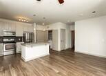 Located at 675 Lafayette Ave in Fayetteville, Georgia, this single-floor residence offers a thoughtfully designed layout with a clean, modern aesthetic throughout. The kitchen serves as a central highlight, showcasing white cabinetry with arched-panel detailing, a mosaic tile backsplash, and a full suite of stainless steel appliances including a refrigerator, range, and microwave. A central island topped with granite countertops provides ample workspace and includes an integrated sink, dishwasher, and pendant lighting overhead, making it both functional and visually appealing.

The living area is finished with warm hardwood-style flooring and features multiple windows dressed with horizontal blinds, allowing generous natural light to fill the space. A ceiling fan adds comfort and practicality. The bedroom is carpeted for warmth and comfort, also equipped with a ceiling fan and well-positioned windows that bring in additional natural light.

The bathroom is finished with granite countertops on the vanity, hardwood-style flooring, and a tiled tub-and-shower combination featuring classic white subway tile. An adjacent walk-in closet with built-in shelving provides convenient and organized storage. Overall, the space presents a cohesive and comfortable living environment with quality finishes throughout.