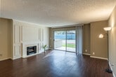 This well-designed two-bedroom, three-bathroom single-story home at 3700 S Plaza offers a functional and comfortable layout across a thoughtfully organized floor plan. The combined kitchen and living room serves as the heart of the home, featuring rich hardwood-style flooring, a classic fireplace with decorative wall paneling, and large sliding glass doors that open to a private patio with outdoor views, flooding the space with natural light. The kitchen is equipped with dark espresso cabinetry, granite countertops, a mosaic tile backsplash, and a full suite of stainless steel appliances including a gas range, dishwasher, and refrigerator with an in-door water and ice dispenser. The bedrooms are carpeted for comfort, with the generously sized primary bedroom offering ample natural light through a wide window. The primary bathroom features a dual-sink vanity with granite countertops, dark cabinetry, a mirrored sliding closet, and a separate shower and tub area. Three additional bathrooms provide flexibility for guests and household members alike. The home includes four closets for generous storage, a dedicated laundry room with full-size washer and dryer and overhead cabinetry, a hallway, and a welcoming entrance. Textured ceilings are present throughout the home.