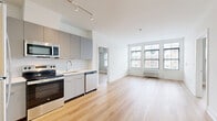 This well-appointed 2-bedroom, 2-bathroom residence at 10 W Westfield Ave in Roselle Park, NJ offers a thoughtfully designed layout with modern finishes throughout. Light-toned hardwood-style flooring runs continuously across the entire unit, creating a cohesive and bright aesthetic.

The open-concept kitchen and living area serves as the heart of the home. The kitchen is outfitted with sleek gray flat-front cabinetry, stainless steel appliances including a refrigerator, range, microwave, and dishwasher, and a white quartz countertop complemented by a hexagonal tile backsplash. Track lighting illuminates the space effectively. The adjoining living area is generously proportioned and benefits from large windows that invite abundant natural light.

Both bedrooms are well-sized, with the primary bedroom offering a comfortable footprint, double-door closet, and a window with outdoor views. The second bedroom also features windows with exterior views and dedicated closet space. Four closets are distributed throughout the unit, providing excellent storage.

The two bathrooms are finished in a clean, modern style with gray vanities, white quartz countertops, large mirrors, and light tile flooring. One bathroom features a glass-enclosed walk-in shower, while the other is spacious with grab bar accessibility features. An in-unit laundry area adds everyday convenience to this move-in-ready residence.